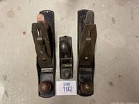 Top view showing three woodworking hand planes arranged side by side, including two large Stanley Bailey No.14 planes and one smaller No.6 plane.