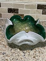 Top angled view showing the folded rim and green interior with gold flecks.