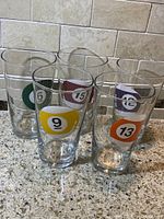 Front view of five Libbey Duratuff glasses with billiard ball designs numbered 6, 9, 12, 13, and 15.