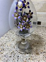 Full view of the Franklin Mint crystal egg showing the floral enamel decoration inside and pedestal base.