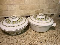 Two vintage Noritake covered bowls with lids displayed side by side, showing top decorative palm and floral pattern.