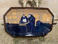 Top view of the serving plate showing monks scene with blue and ochre background