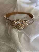 Close-up front view of vintage Ledo rose gold-tone bracelet with baguette clear rhinestones and circular cluster centerpiece.