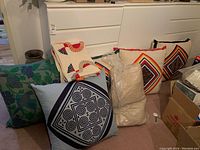 All cushions and quilts arranged on floor and sofa, showing colors and patterns