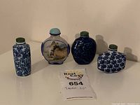 Four assorted snuff bottles displayed in a row