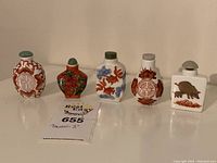Five bottles displayed in a row showing overall shapes and designs