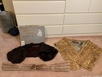 Three vintage Siberian fur shawls laid out on carpet showing different colors and styles.