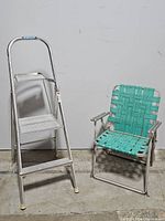 Front view of Werner aluminum 2 step ladder and woven aluminum yard chair.