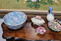 Photo displaying all ceramic items on wooden table including floral bowl, rose dish, porcelain rose figurine, flower basket figurine, and Lenox bud vase.