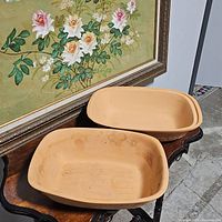 Both clay baking dishes placed side by side showing interior and exterior design.
