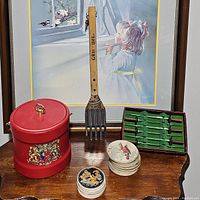 Wide shot showing all items: red ice bucket, grilling spatula, bird coasters, green-handled kebab skewers in tray, and Greek style coasters.