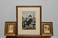 Three framed portraits, biggest in center showing Dutch boy and girl by a windmill, smaller side portraits of children.