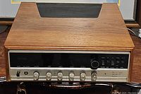 Front view showing the wooden casing and control panel with multiple knobs.