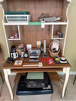 Overview of the miscellaneous office items on and around the desk including electronics and office supplies.