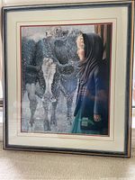 Framed print showing an Amish girl next to a cow with snow falling around them.