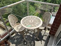 Front view showing table and two chairs on balcony
