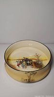 Top-down view of the antique Royal Doulton bowl showing the horse-drawn coach scene painted inside the bowl.