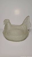 Full shot of the hen-shaped glass dish with lid sitting on the basket base.