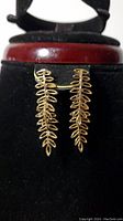 Front view of the pair of gold colored leaf earrings showing the two leaf stems per earring.