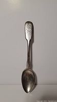 Full view of the tea spoon showing the entire length and shape from handle to bowl.