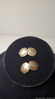 Two-tone sterling silver cufflinks placed on black velvet display. Photo shows front view and pattern detail.