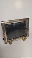 Front and side view of the rectangular sterling silver picture frame showing tarnishing and repair needs.