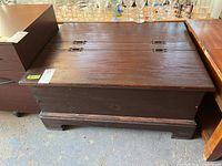 Top view of closed wooden chest showing double hinged lid and metal hinges.