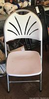 Front view of a single off-white folding chair showing resin seat and back with metal frame.