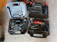 Two hard plastic carry cases opened showing Black & Decker jigsaw model JS300 and rotary saw model RS250 with cords and bits