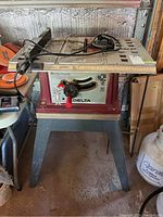 Front view of Delta table saw with stand showing work surface, power cord, and general condition.