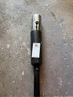 Close-up photo of the top burner section of the black BernzOmatic tiki torch showing the perforated metal gas burner and the black cylindrical body below it.