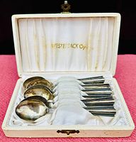Six silver teaspoons arranged in original white jewelers box with satin lining embossed 'WESTERBACK Oy' in gold.