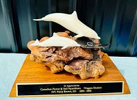Front view of the dolphin sculpture on wood base with appreciation plaque
