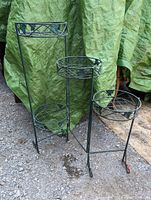 Photo of 3 tier folding metal plant stand showing all three circular plant holders with decorative metalwork
