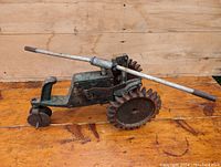 Front-left side view showing small front wheel, large toothed drive wheel, and overall tractor-shaped body