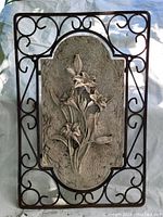 Full view of the metal and resin wall hanging showing overall shape and design.