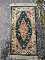 Top-down view of rectangular vintage rug with central medallion and fringe