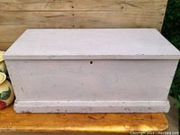 Closed view of vintage pine painted blanket chest showing rectangular shape, flat top, and painted exterior with visible signs of wear and age.