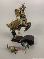 Full view of three cloisonné animal sculptures: horse on base, crane, and elephant.