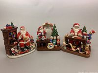 Group shot of three Royal Doulton figurines: Santa’s Toy Testing, Santa Makes His List, Santa’s Workshop