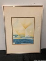 Full view of the framed watercolour painting showing the entire artwork and frame, artwork displays an abstract landscape in blues and yellows.