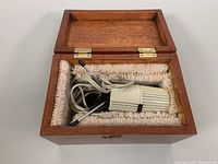 Microphone packed inside the open wooden carrying box, showing plush lining and anatomy of microphone with cable wrapped inside box