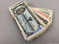 Stack of $1 Canadian Tire Money coupons secured with rubber band showing blue borders and black and white portraits