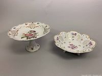 Pedestal compote and footed bowl together showing floral and gold hand painted design.