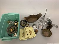 Overview of lot showing plastic bin with metal items, tin trays, brass Monteith cachpot, small bowls, squirrel nutcracker, metal crane and owl dishes.