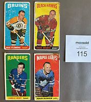 Front view of all four 1964-65 Tall Boys hockey cards showing players Reg Fleming, Doug Mohns, Camille Henry, and Johnny Bower from different NHL teams.