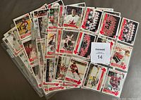 Photo showing binder pages filled with hockey cards from the 1976 Canada Cup series laid out on a surface.