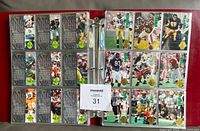 Open binder page showing two rows of ten football cards with player images and stats on the back.
