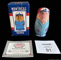 Photo showing largest Andres Galarraga nesting doll next to original box and COA, all arranged on flat surface