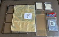 Lot of card collecting supplies including 9 card pages, two hard plastic card holders, and screwdown holders still in packaging.